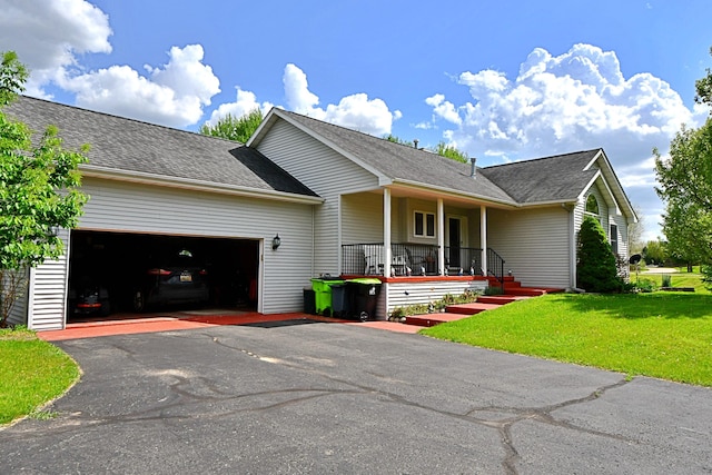 4930 Warrington Way, Gladwin, MI 48624 - view of front of home with covered porch, a garage, a front yard, asphalt driveway, and a shingled roof