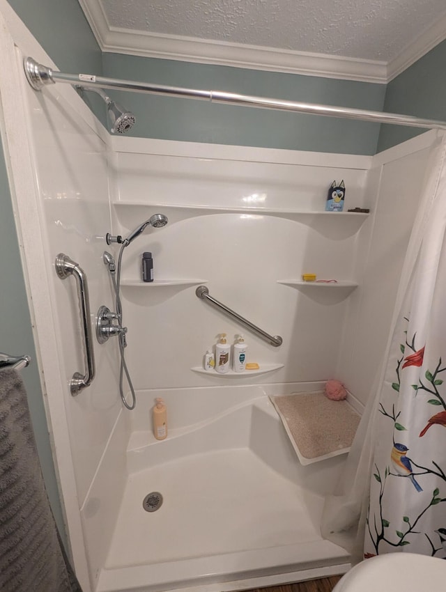 9367 Clewley Rd, Lachine, MI 49753 - full bathroom with ornamental molding, a shower stall, a textured ceiling, and toilet