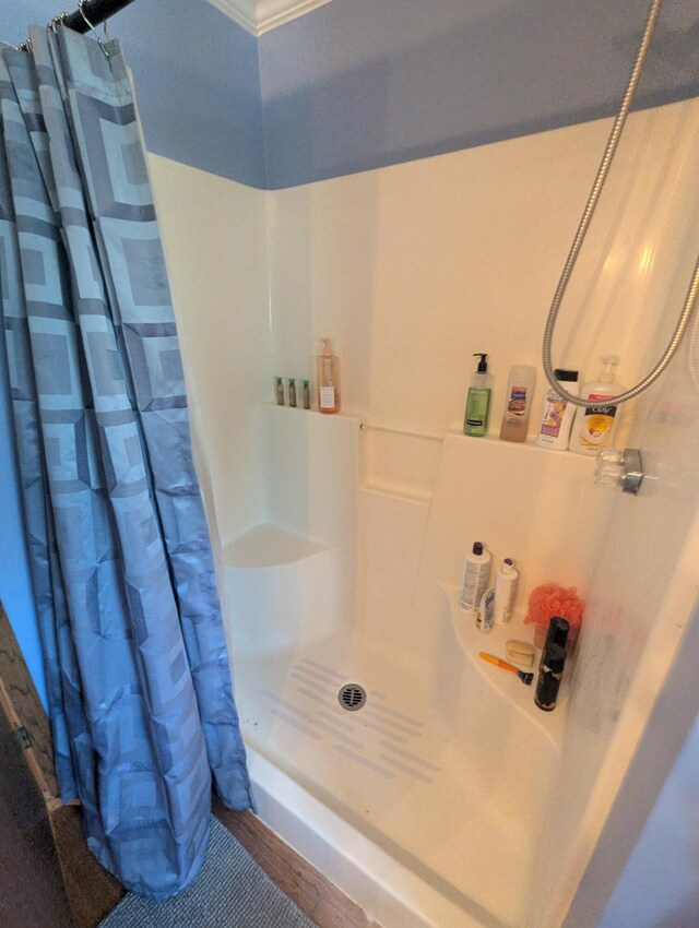 9367 Clewley Rd, Lachine, MI 49753 - full bathroom featuring a shower with curtain, ornamental molding, and wood finished floors