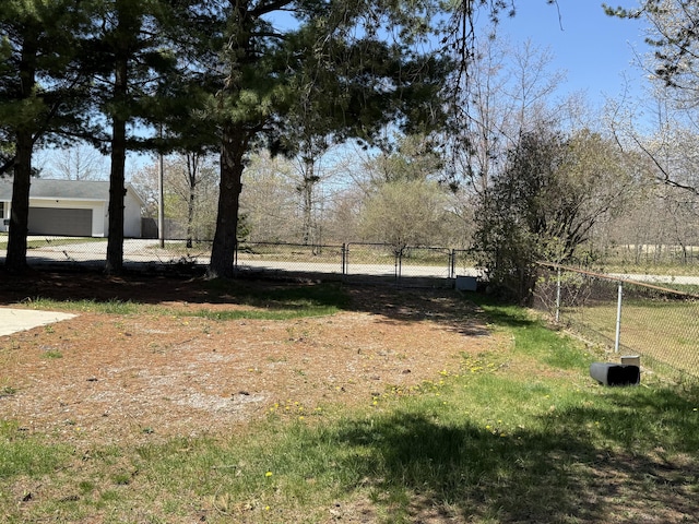 view of yard with fence, a garage, and a gate