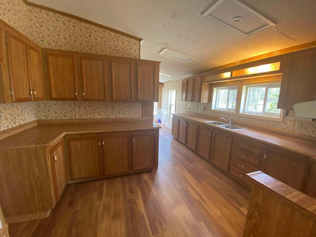 1364 Lakeview Dr, Mio, MI 48647 - kitchen with wallpapered walls, a sink, brown cabinets, wood finished floors, and a textured ceiling