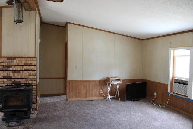 1364 Lakeview Dr, Mio, MI 48647 - unfurnished living room with a wood stove, ornamental molding, wooden walls, carpet floors, and cooling unit
