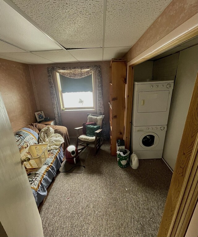 20417 State St, Onaway, MI 49765 - bedroom featuring stacked washing machine and dryer, carpet flooring, and a drop ceiling