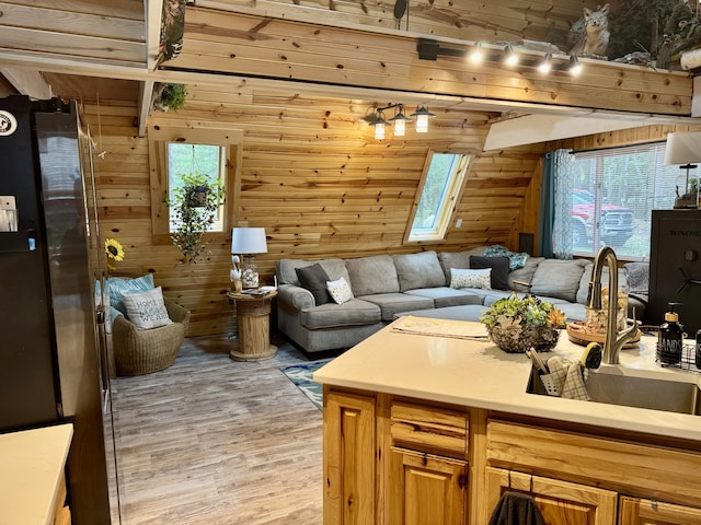2733 Timberlane Trl, Grayling, MI 49738 - living room featuring wooden walls, light wood finished floors, and a skylight