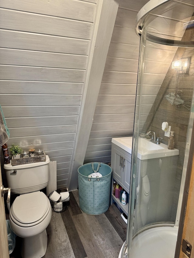 2733 Timberlane Trl, Grayling, MI 49738 - bathroom with wood finished floors, a stall shower, toilet, vanity, and wood walls