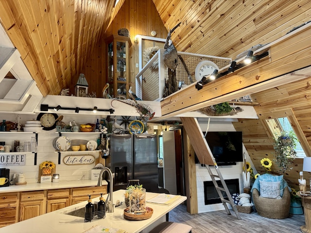 2733 Timberlane Trl, Grayling, MI 49738 - kitchen featuring wooden walls, stainless steel fridge with ice dispenser, a sink, lofted ceiling, and light wood-style flooring