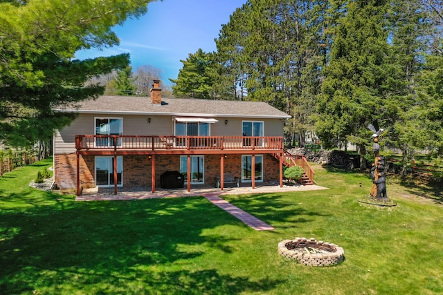 rear view of house featuring stairway, a deck, a fire pit, and a patio