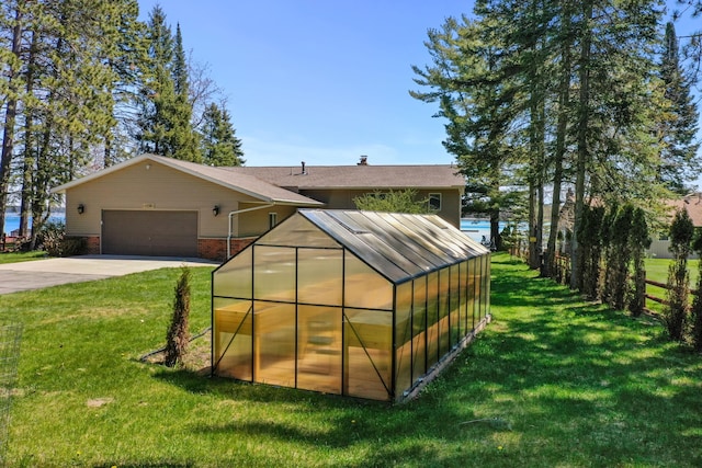 view of outbuilding featuring a garage, concrete driveway, and an outdoor structure