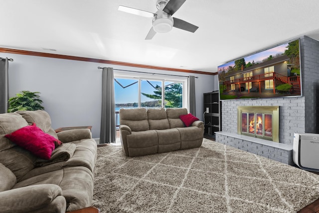living area featuring crown molding, a fireplace, and a ceiling fan
