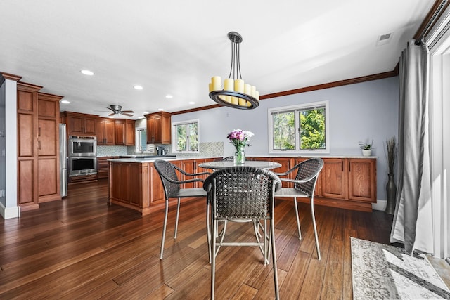 dining space with ornamental molding, healthy amount of natural light, dark wood finished floors, recessed lighting, and ceiling fan