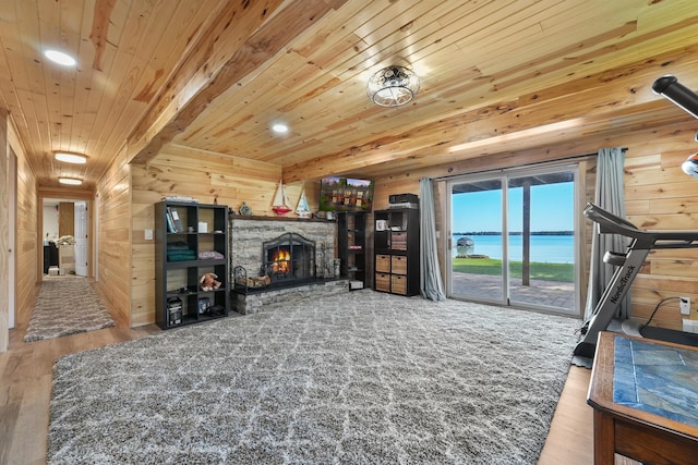 living room with wood ceiling, wood finished floors, a stone fireplace, wood walls, and recessed lighting