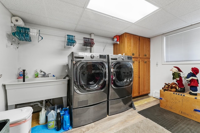 laundry area featuring cabinet space, washer and clothes dryer, and wood finished floors