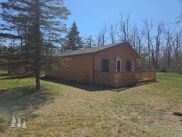 4795 Bruce Dr, Lewiston, MI 49756 - view of property exterior with a deck, a yard, and roof with shingles