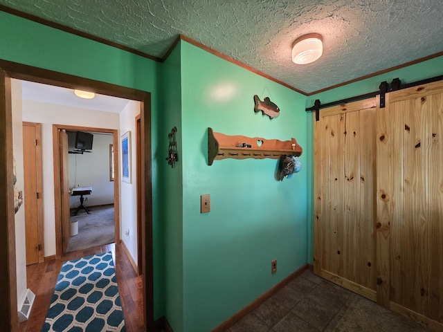 2623 W Dixon Lake Dr, Gaylord, MI 49735 - hall featuring a barn door, crown molding, a textured ceiling, and baseboards
