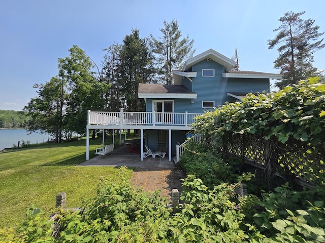 2623 W Dixon Lake Dr, Gaylord, MI 49735 - rear view of property featuring a wooden deck, a patio area, and a lawn