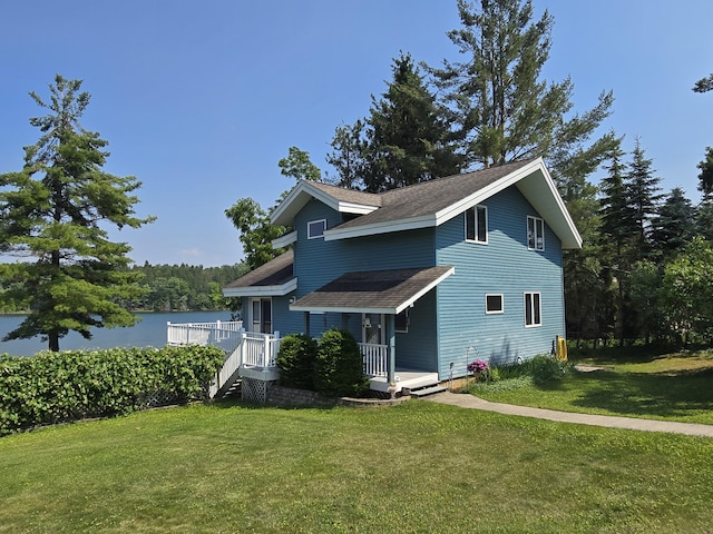 2623 W Dixon Lake Dr, Gaylord, MI 49735 - traditional-style home featuring a front lawn, roof with shingles, a porch, and a water view