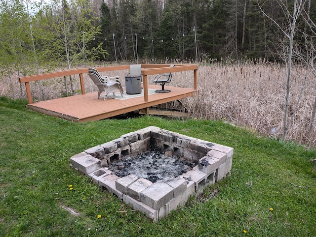 20563 S M32, Hillman, MI 49746 - view of grassy yard featuring a fire pit, a wooden deck, and a forest view