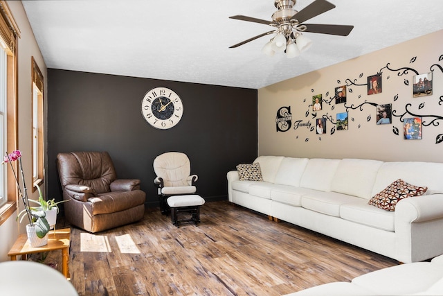 11758 Woodview Trl, Gaylord, MI 49735 - living room featuring an accent wall, a ceiling fan, and wood finished floors