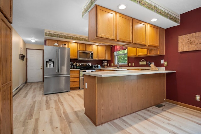 11758 Woodview Trl, Gaylord, MI 49735 - kitchen featuring stainless steel appliances, a baseboard radiator, light wood finished floors, a peninsula, and a sink