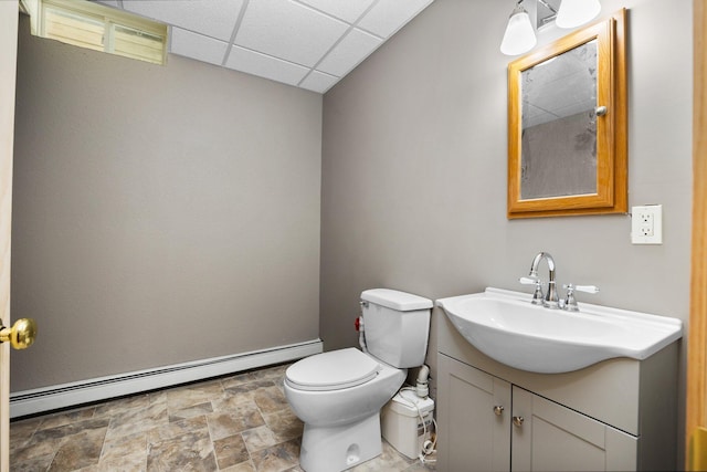 11758 Woodview Trl, Gaylord, MI 49735 - half bath featuring baseboard heating, stone finish flooring, a paneled ceiling, vanity, and toilet