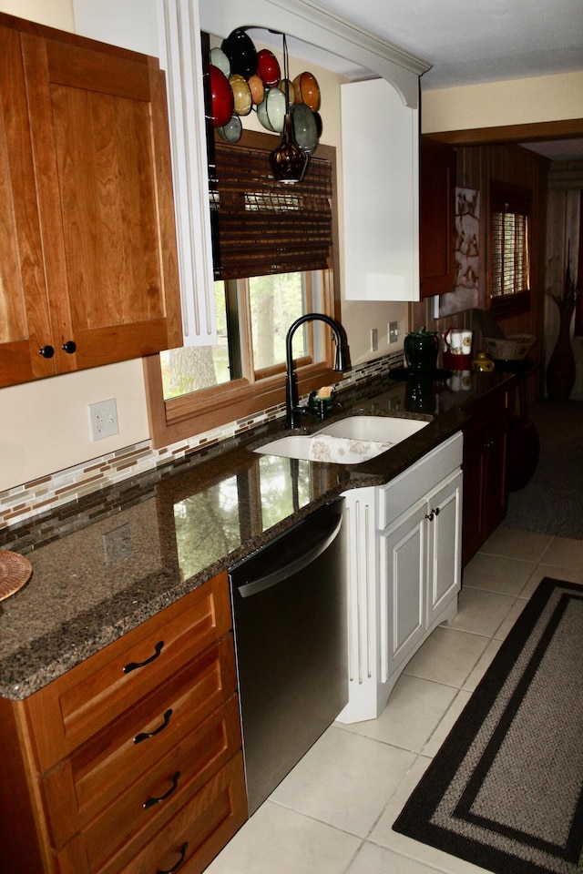 6475 W Legner Trl, Grayling, MI 49738 - kitchen featuring dishwasher, a sink, light tile patterned floors, and dark stone countertops
