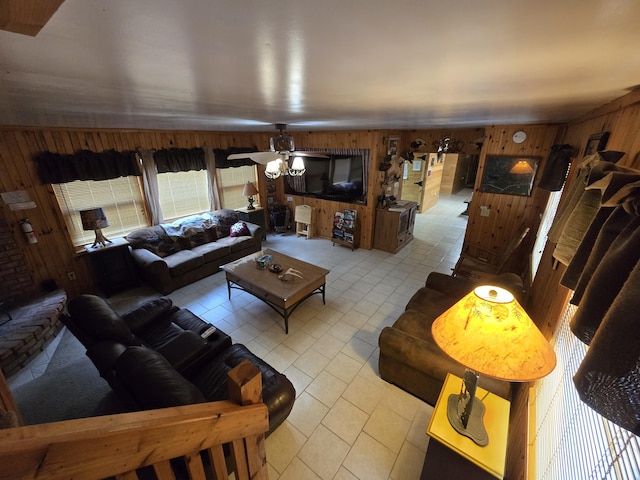 7912 Millecoquin Trl, Gaylord, MI 49735 - living room featuring wood walls, light tile patterned flooring, and a ceiling fan