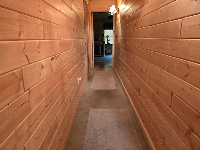 7912 Millecoquin Trl, Gaylord, MI 49735 - hallway featuring wood walls and concrete floors