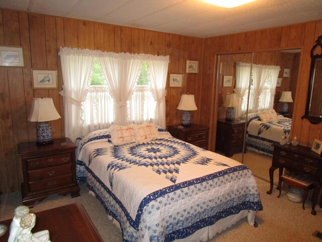 541 Ranch Rd, Indian River, MI 49749 - carpeted bedroom with wood walls and a closet