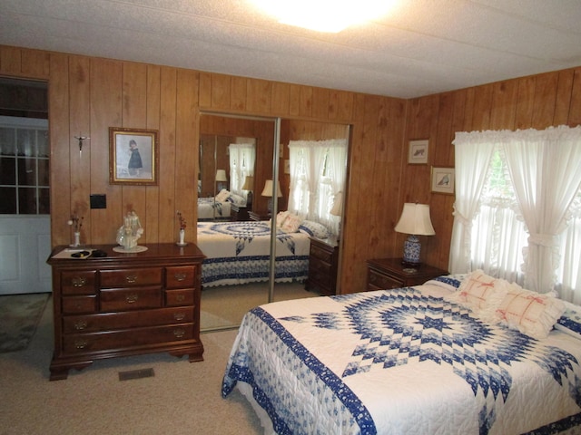 541 Ranch Rd, Indian River, MI 49749 - carpeted bedroom featuring a closet, multiple windows, and wood walls