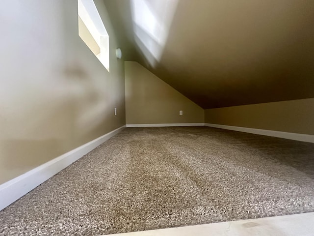 additional living space with lofted ceiling and baseboards