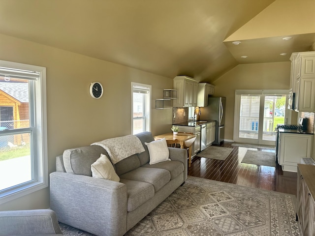 living area with plenty of natural light, dark wood-style flooring, lofted ceiling, baseboards, and recessed lighting