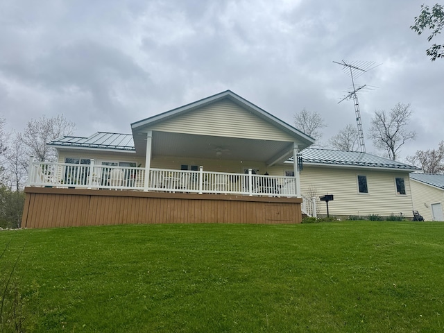 870 Dalton Dr, Rose City, MI 48654 - rear view of house featuring a standing seam roof, metal roof, a lawn, and a deck