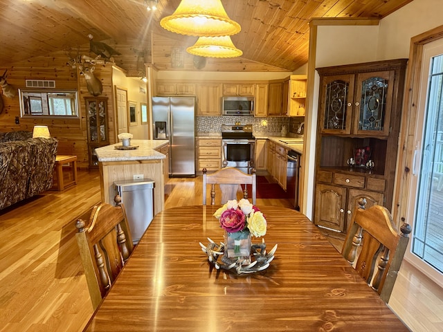 870 Dalton Dr, Rose City, MI 48654 - dining space featuring vaulted ceiling, wooden ceiling, light wood-type flooring, and wood walls
