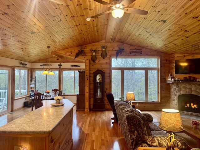 870 Dalton Dr, Rose City, MI 48654 - living area featuring wooden walls, light wood-style floors, wood ceiling, a fireplace, and a ceiling fan