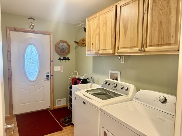 870 Dalton Dr, Rose City, MI 48654 - laundry room featuring washing machine and dryer, cabinet space, and light wood finished floors