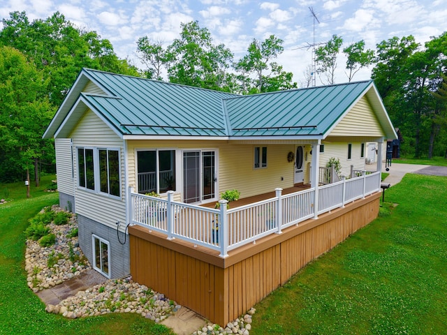 870 Dalton Dr, Rose City, MI 48654 - rear view of house featuring a standing seam roof, a lawn, and a metal roof