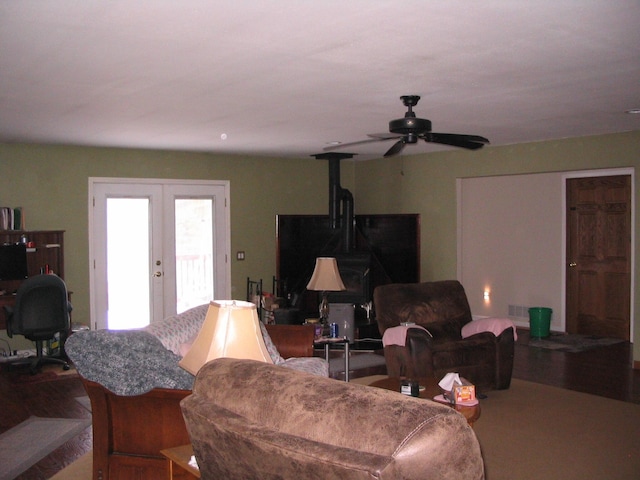 5198 Troopers Trl, Frederic, MI 49733 - living room featuring french doors, ceiling fan, wood finished floors, and a wood stove