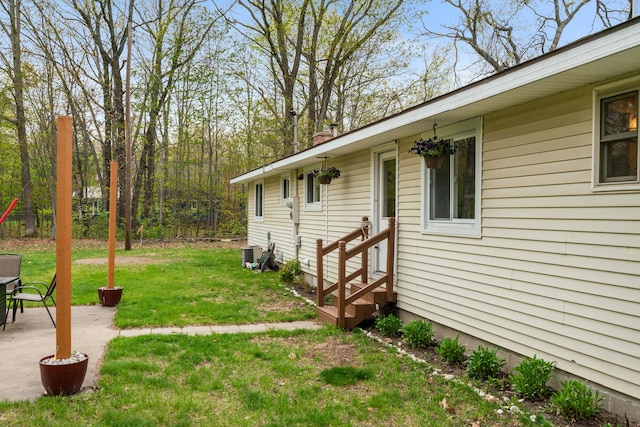 6727 Fisher Woods Rd, Indian River, MI 49749 - view of grassy yard featuring entry steps, a patio, and central air condition unit
