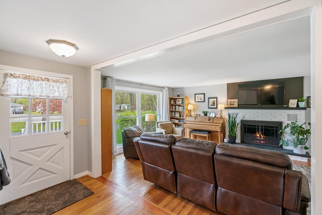 6727 Fisher Woods Rd, Indian River, MI 49749 - living room with light wood-style flooring, a brick fireplace, and baseboards