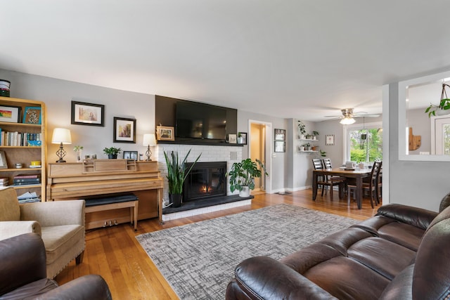 6727 Fisher Woods Rd, Indian River, MI 49749 - living area featuring a fireplace, ceiling fan, and wood-type flooring