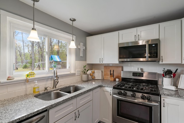 6727 Fisher Woods Rd, Indian River, MI 49749 - kitchen featuring stainless steel appliances, a sink, white cabinetry, and backsplash