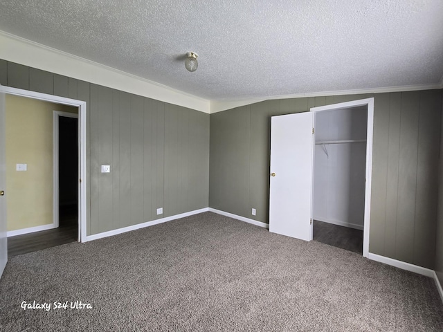 72 Chelsey Ln, Cheboygan, MI 49721 - unfurnished bedroom featuring a textured ceiling, dark carpet, a closet, ornamental molding, and baseboards