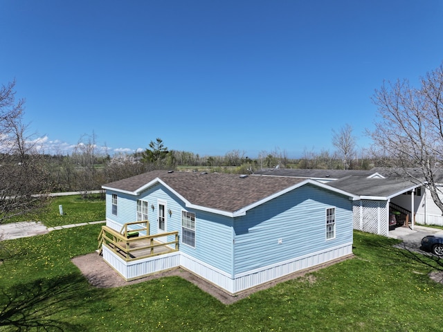 72 Chelsey Ln, Cheboygan, MI 49721 - view of side of home featuring a carport, a lawn, and a shingled roof