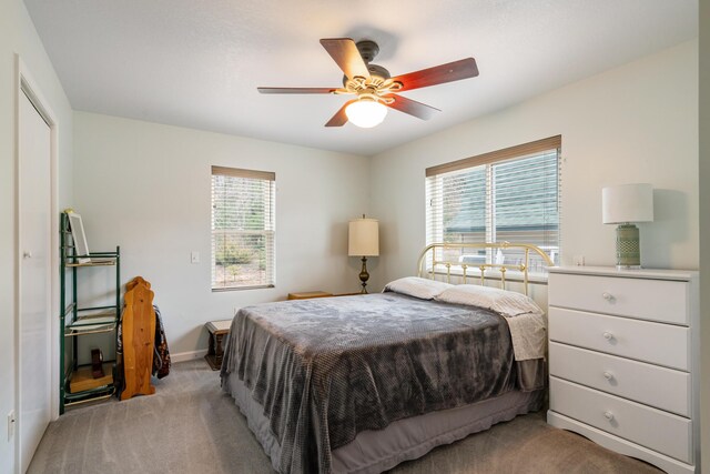 2286 Maxwell Rd, Petoskey, MI 49770 - bedroom with light carpet, multiple windows, baseboards, and ceiling fan