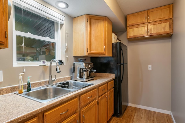 2286 Maxwell Rd, Petoskey, MI 49770 - kitchen with a sink, light wood-style flooring, light countertops, and brown cabinets