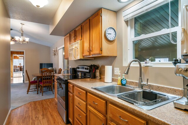 2286 Maxwell Rd, Petoskey, MI 49770 - kitchen featuring electric stove, white microwave, a sink, brown cabinets, and vaulted ceiling