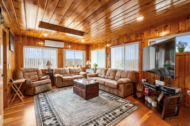 2286 Maxwell Rd, Petoskey, MI 49770 - living area featuring an AC wall unit, wooden ceiling, wood walls, and light wood finished floors