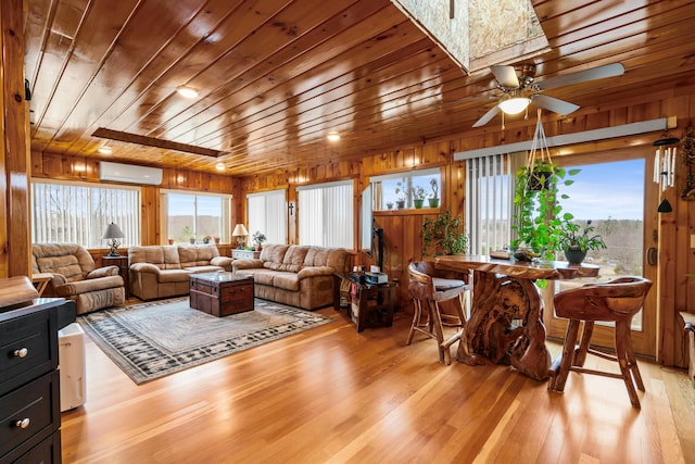 2286 Maxwell Rd, Petoskey, MI 49770 - living area with a wall mounted air conditioner, light wood-style floors, ceiling fan, wood walls, and wood ceiling