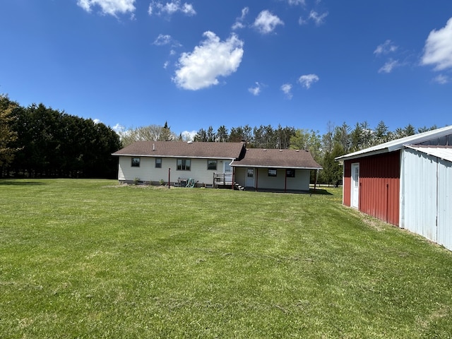 6870 N Spruce Rd, Spruce, MI 48762 - rear view of house featuring a lawn, an outdoor structure, and a pole building