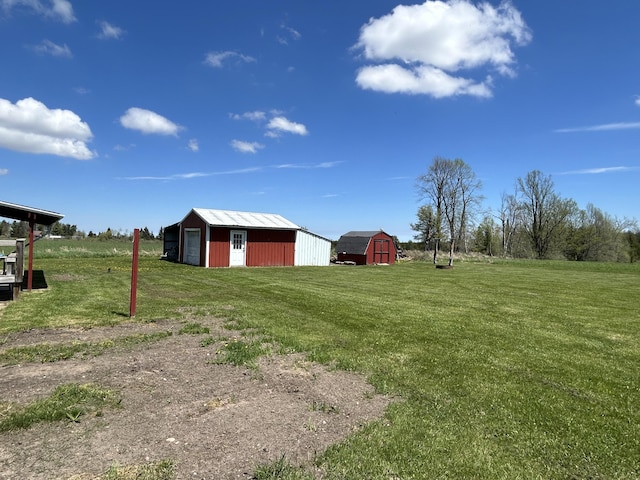 6870 N Spruce Rd, Spruce, MI 48762 - view of grassy yard with an outdoor structure, a detached garage, and a storage shed
